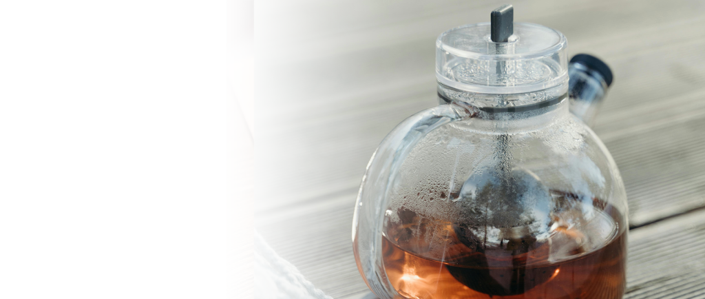 Glass teapot with a removable infuser on a wooden table